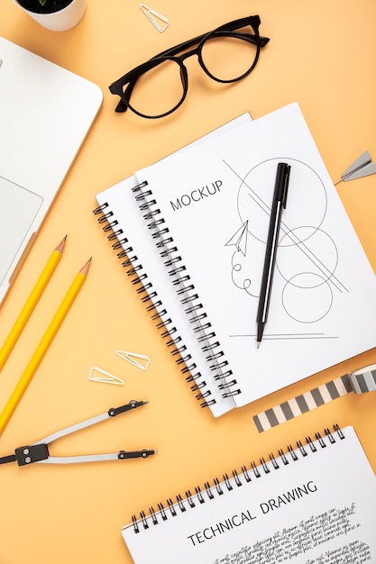 Flat lay of desk surface with notebook and glasses