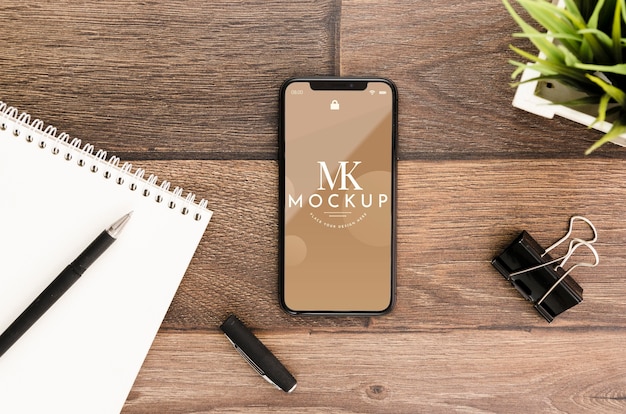 Flat lay smartphone mock-up with motepad on desk