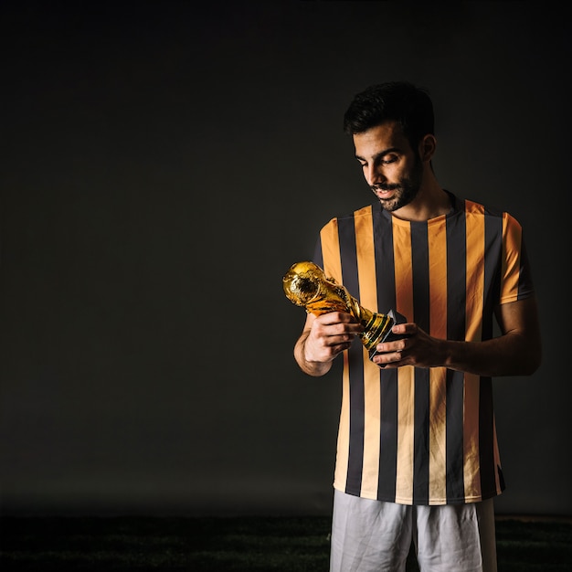 Football player looking at trophy