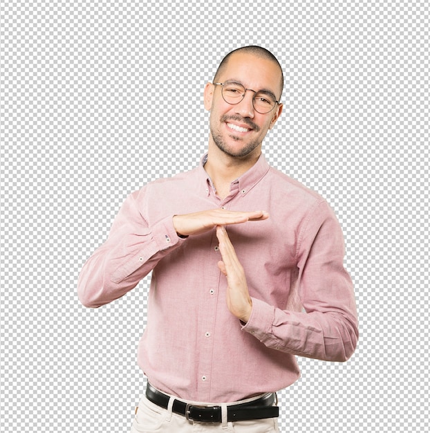 Friendly young man making a time out gesture with his hands