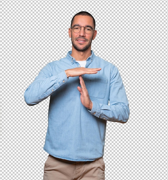 Friendly young man making a time out gesture with his hands