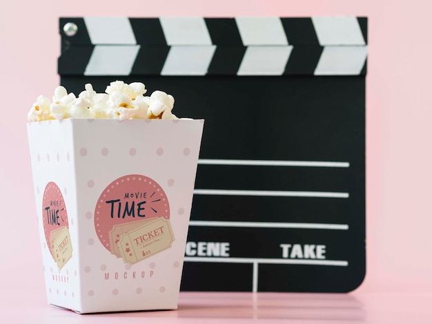 Front view of cinema clapperboard and popcorn