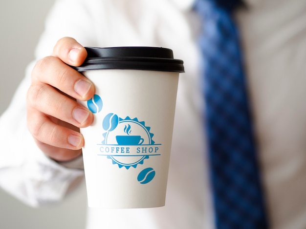 Front view man holding a cup of coffee mock-up