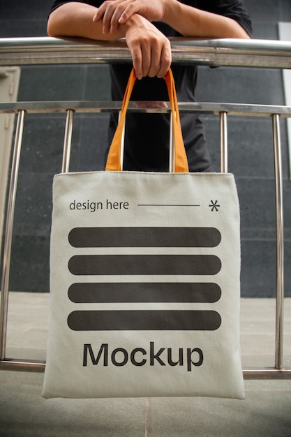 Front view man holding totebag mockup