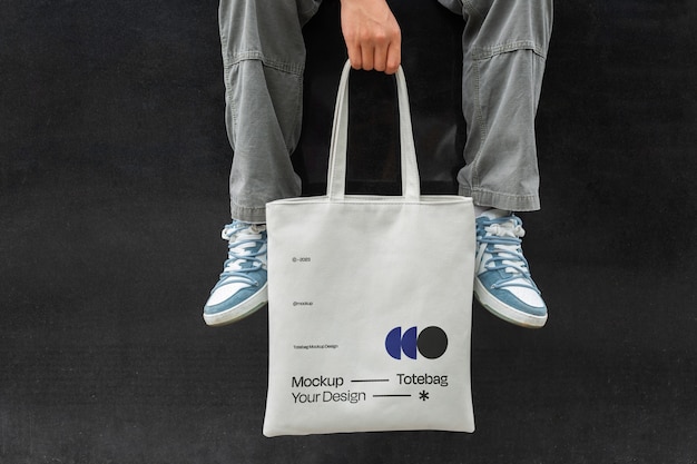 Front view man holding totebag mockup