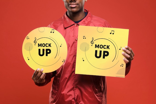 Front view of man holding vinyl disk for music store mock-up