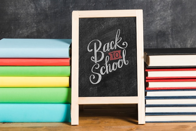 Front view pile of books with chalkboard