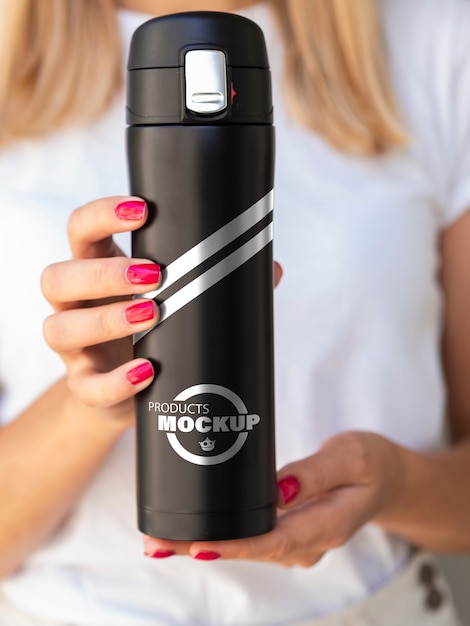 Front view woman holding a black thermos mock-up