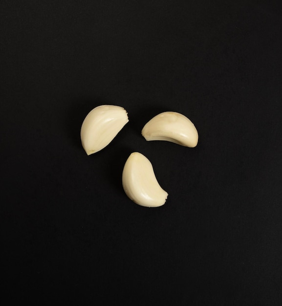 Garlic cloves on black background