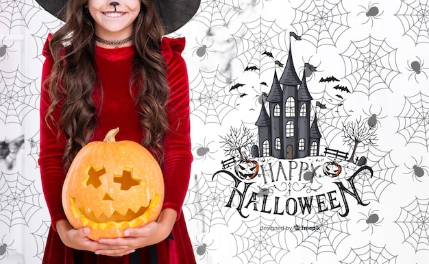 Girl holding a carved pumpkin for halloween party