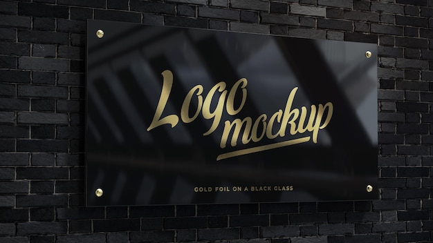 Gold foil logo mockup on a balck galss plate on the wall