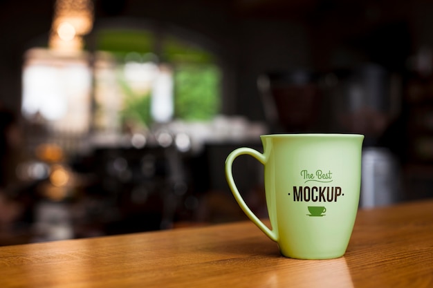 Green coffee cup on wooden table