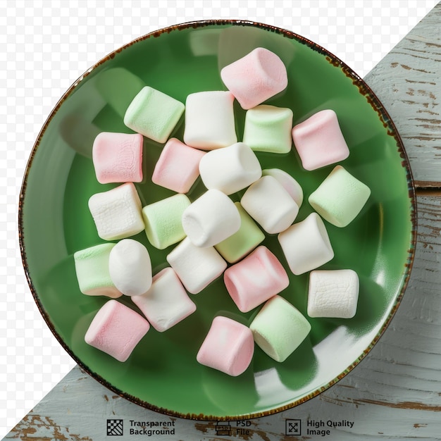 Green plate with marshmallow on white wooden isolated background Top view