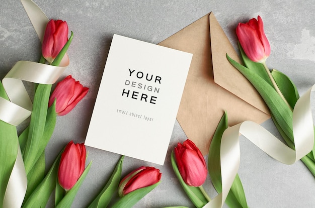 Greeting card mockup with envelope, ribbons and red tulip flowers