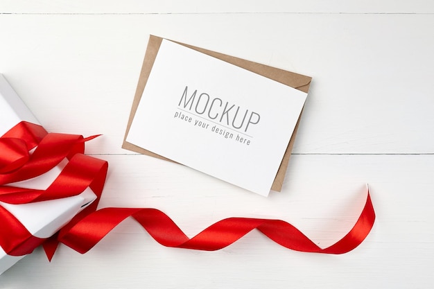 Greeting card mockup with gift box and red ribbon 