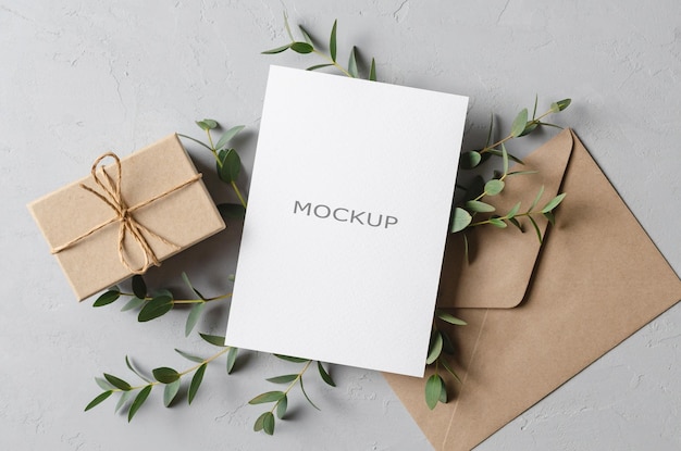 Greeting card mockup with gift envelope and fresh eucalyptus twig