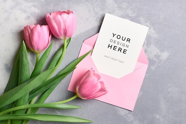 Greeting card mockup with pink envelope and tulip flowers bouquet