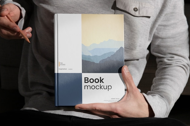 Hand holding book mock-up