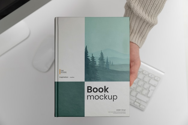 Hand holding book mock-up