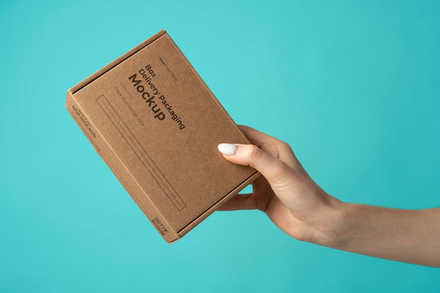 Hand holding delivery box with blue background