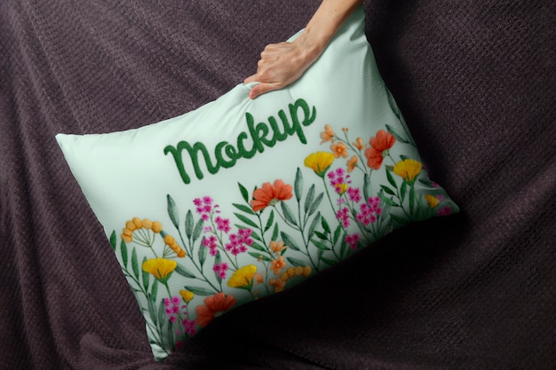 Hand holding floral cushion top view