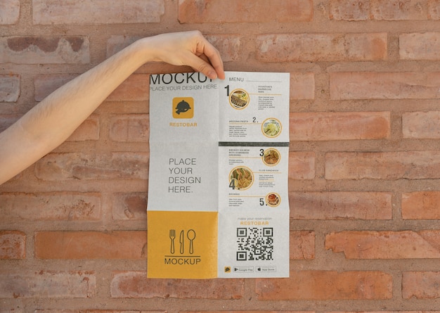 Hand holding folded restobar brochure mock-up