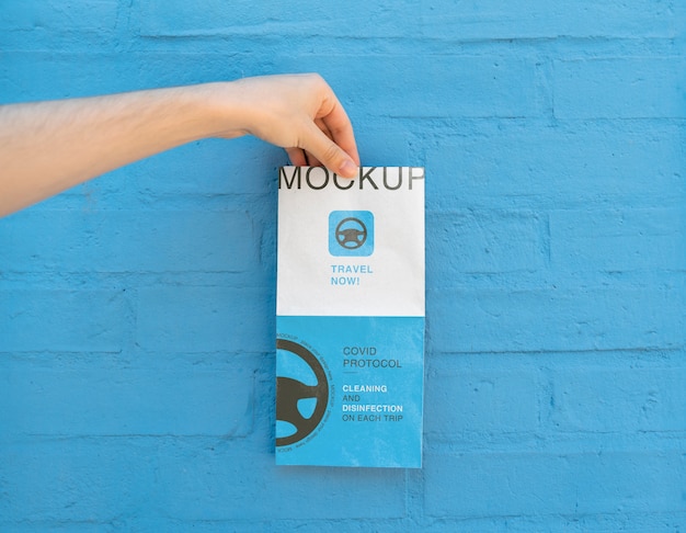 Hand holding folded travel brochure mock-up