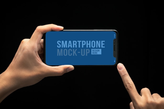 Hand holding modern smartphone and touching screen mockup template for your design