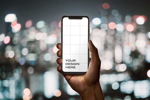 Hand holding new smartphone mockup with bokeh 