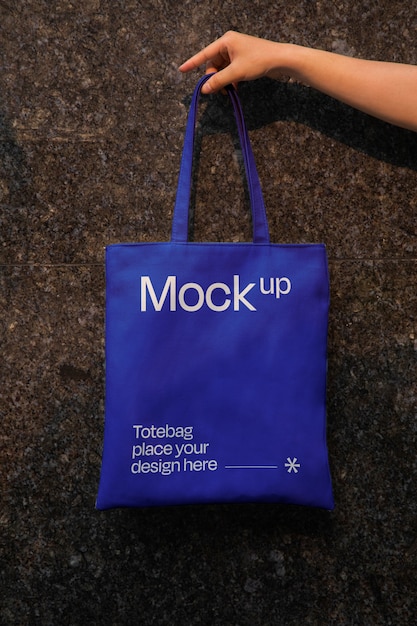 Hand holding totebag mockup