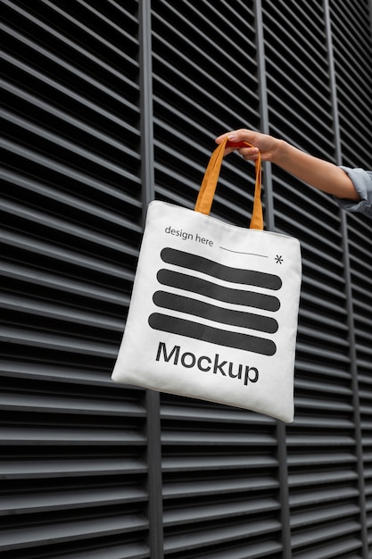 Hand holding totebag mockup