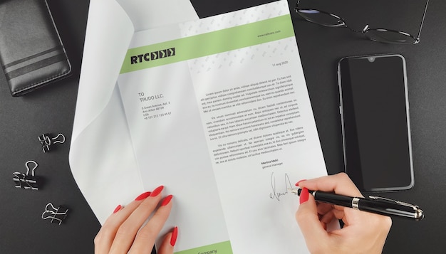 PSD hand signing  paper sheet at workplace top view mockup