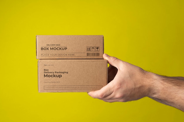 Hands holding boxes with yellow background