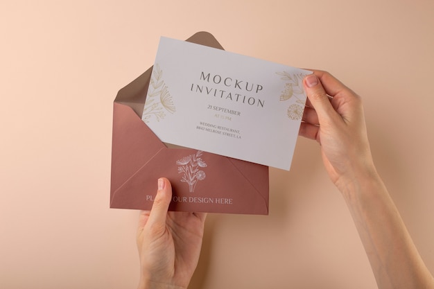 Hands holding paper invitation mock-up