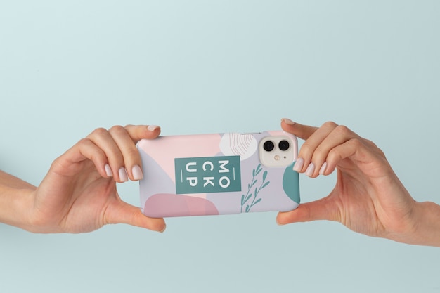 Hands holding smartphone with mock-up phone case