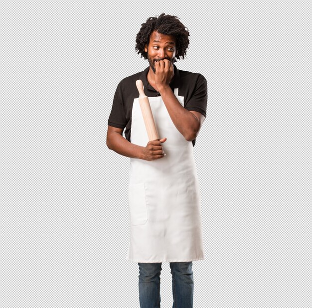 PSD handsome black man baker biting nails, nervous and very anxious and scared for the future, feels panic and stress