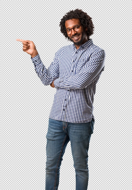 Handsome business african american man pointing to the side, smiling surprised presenting something, natural and casual