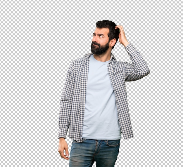 Handsome man with beard having doubts while scratching head