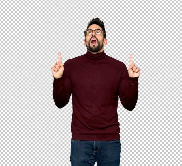 Handsome man with glasses surprised and pointing up