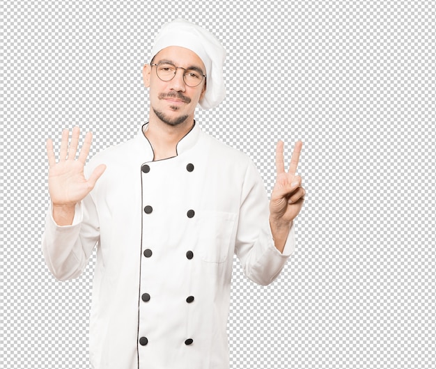 PSD happy young chef doing a number seven gesture with his hands