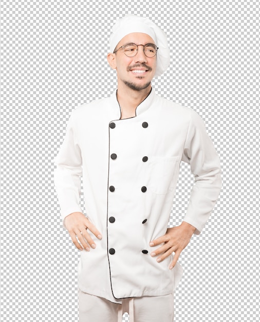 Happy young chef posing against background