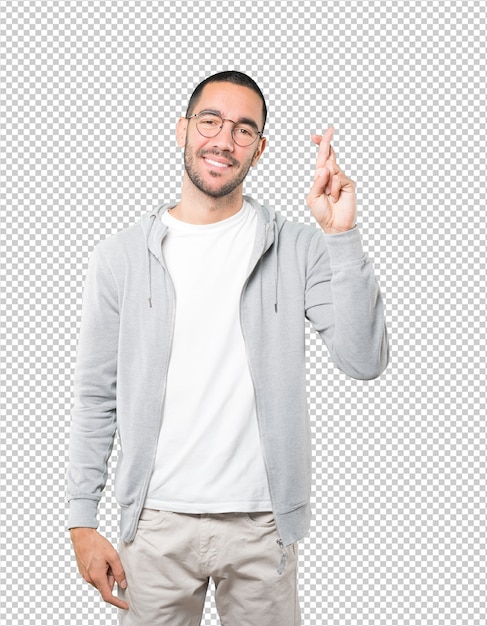 Happy young man doing a crossed fingers gesture