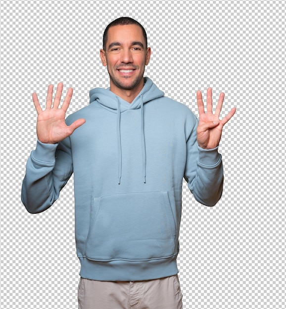 Happy young man doing a number nine gesture with his hands