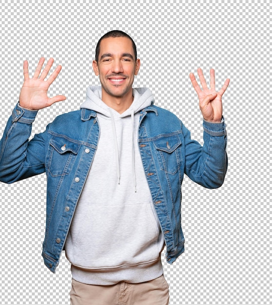 Happy young man doing a number nine gesture with his hands