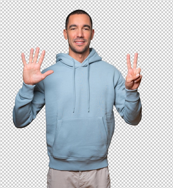 Happy young man doing a number seven gesture with his hands