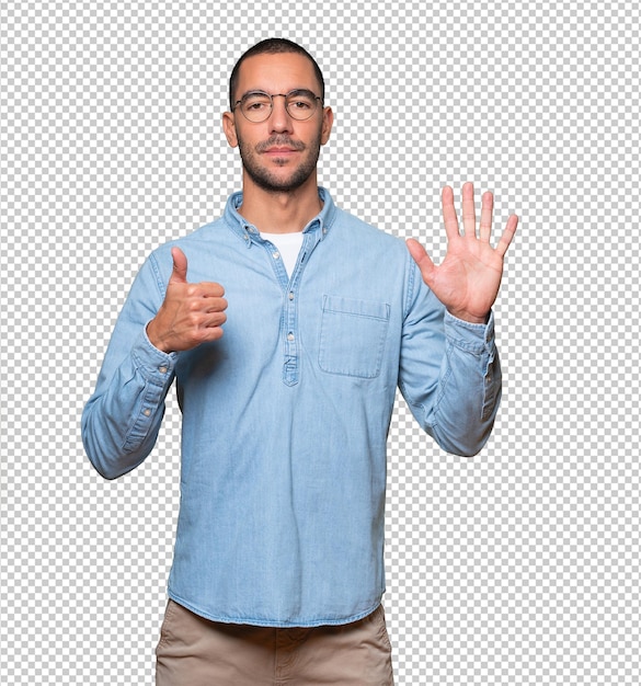 Happy young man doing a number six gesture with his hands