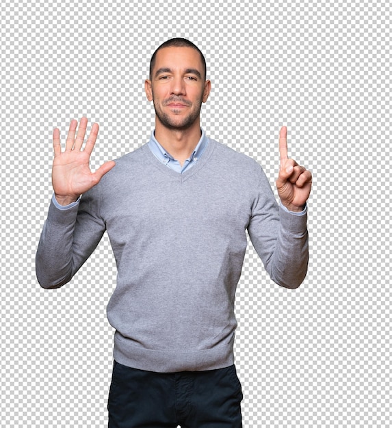 Happy young man doing a number six gesture with his hands