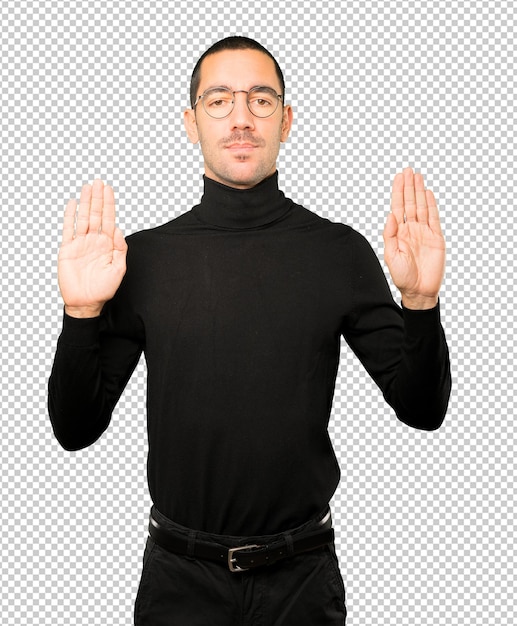 Happy young man making a gesture of stop with his palm