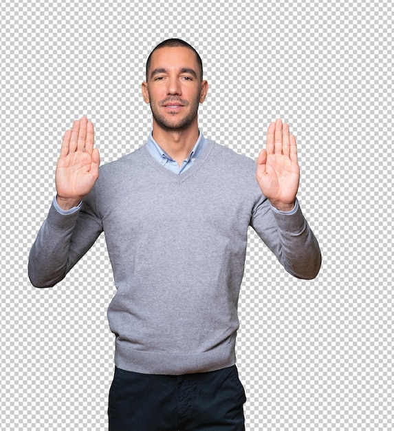 Happy young man making a gesture of stop with his palm