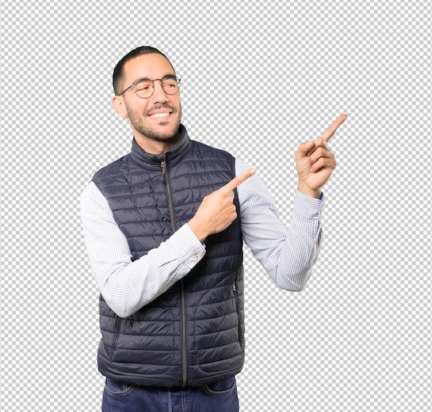 Happy young man pointing up with his finger